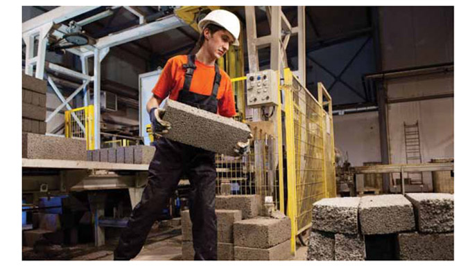 Image of worker lifting concrete blocks.